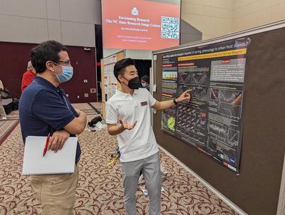 Xiaojie explaining his poster to a captivated attendee
